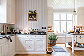 Spacious, white country-house kitchen in renovated manor house