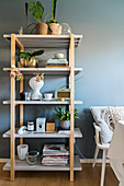 Ornaments and plants on deep, simple shelves against blue-grey wall
