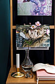 Magazines and vase of Japanese anemones arranged on ladder-back chair used as bedside table