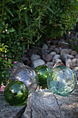 Charming arrangement of glass balls and pebbles in garden