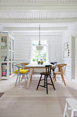 Display cabinet in dining area of white-painted log cabin