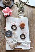 Easter bunnies made from beads used as egg cups on white chopping board