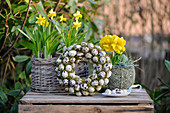 Wreath of quail eggs together with daffidils on a plant box