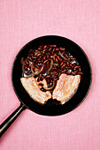 Meat with red kidney beans on frying pan