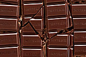 Broken chocolate bar with the word chocolate on each rectangle piece
