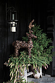 Bark reindeer figure and fir branches next to front door