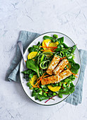Veganer Salat mit gelber Bete, Zucchini, Bohnen und paniertem Tofu