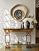 Antique console with marble top and orchid flowers, mirror above