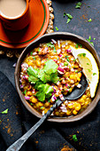 Indian vegan lentil curry served with chopped onion, green chiles, cilantro