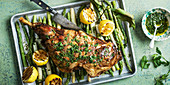 Roasted meat on asparagus in baking tray