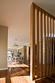 Round table in dining area with slatted wooden partition in foreground