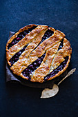 Cherry pie with a lattice and flaky crust shot on blue background