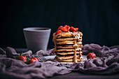 Pancake-Stapel mit Erdbeeren, Erdnussbutter und Ahornsirup