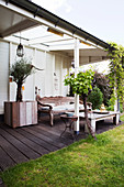 Überdachte Terrasse mit orientalischer Holzbank und Olivenbaum