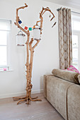 Knorriger Baum mit Laternen als Deko hinter dem Sofa