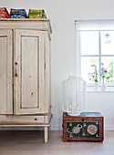 Ethnic trunk and lantern next to white cupboard