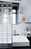 Glass-brick partition screening sunken bathtub