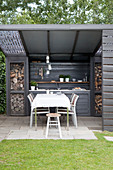 Essplatz und Outdoor-Küche in Grau auf überdachter Terrasse