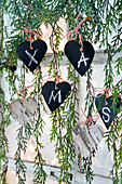 DIY hearts ade of wood and cardboard painted with chalkboard paint with 'XMAS' lettering