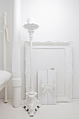 White picture frame and candlestick against white wall