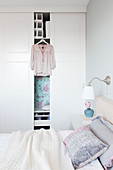 Blouse hung on whit wardrobe in bright bedroom