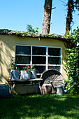Trödel vorm Schopf mit Sprossenfenster im sommerlichen Garten