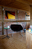Modern armchair in a rural living room with half-timbering and brick wall