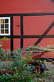 Schublade mit Grünschnitt am roten Fachwerkhaus im Herbst