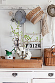 Jug of twigs on wooden tray with vintage flea-market accessories