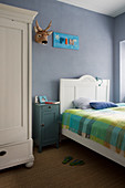 Antique furniture and grey-blue walls in child's bedroom