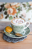 Macaron with a cup of cocoa with whipped cream