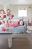 Dahlien und Blütenzweig im Wohnzimmer mit Deko in Rosa und Pink