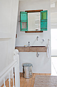 Türkises Dekofenster mit Spiegel überm Waschbecken aus Stein