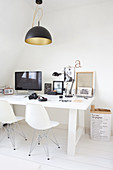 Black-and-white utensils on white desk and white classic chairs
