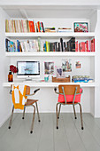 Vintage chairs in front of floating desk and shelves in niche