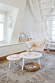 Rattansessel und Tischset in weißem Zimmer mit Gaubenfenster