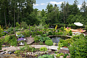 Gartenteich mit Steineinfassung, Holzstegen, Kieswegen und Sonnendeck