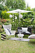 Black and white outdoor furniture, parasols, and party decorations in a summer garden
