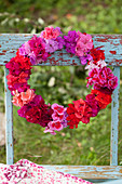Wreath of geranium and azalea flowers in deep pink, red, lilac, pale pink and purple