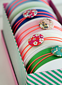Rubber bands with fabric buttons around rollers with fabric straps