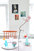 Zweig mit Papierblüten auf dem Tisch mit nostalgischen Vasen