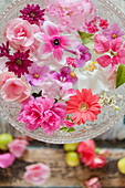 Pale pink and deep pink flowers floating in glass bowl