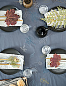 Herbstlich gedeckter Tisch mit bestickter Tischdecke