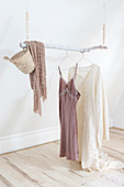 branch hung from wooden beaded necklaces as a clothes rail