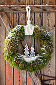 DIY Christmas wreath with little wooden tree on wooden door