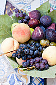 Fresh figs, grapes, and peaches in a bowl