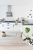 Simple white kitchen with black handles and gray worktop