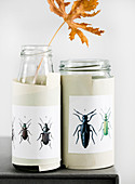 Paper cuffs affixed to screw-top jars with beetle motifs