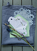 Schneeflocke aus Papier, Traubenhyazinthe und Weidenkätzchen auf einem Briefumschlag