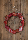 Wreath of red autumn leaves with white decoration
